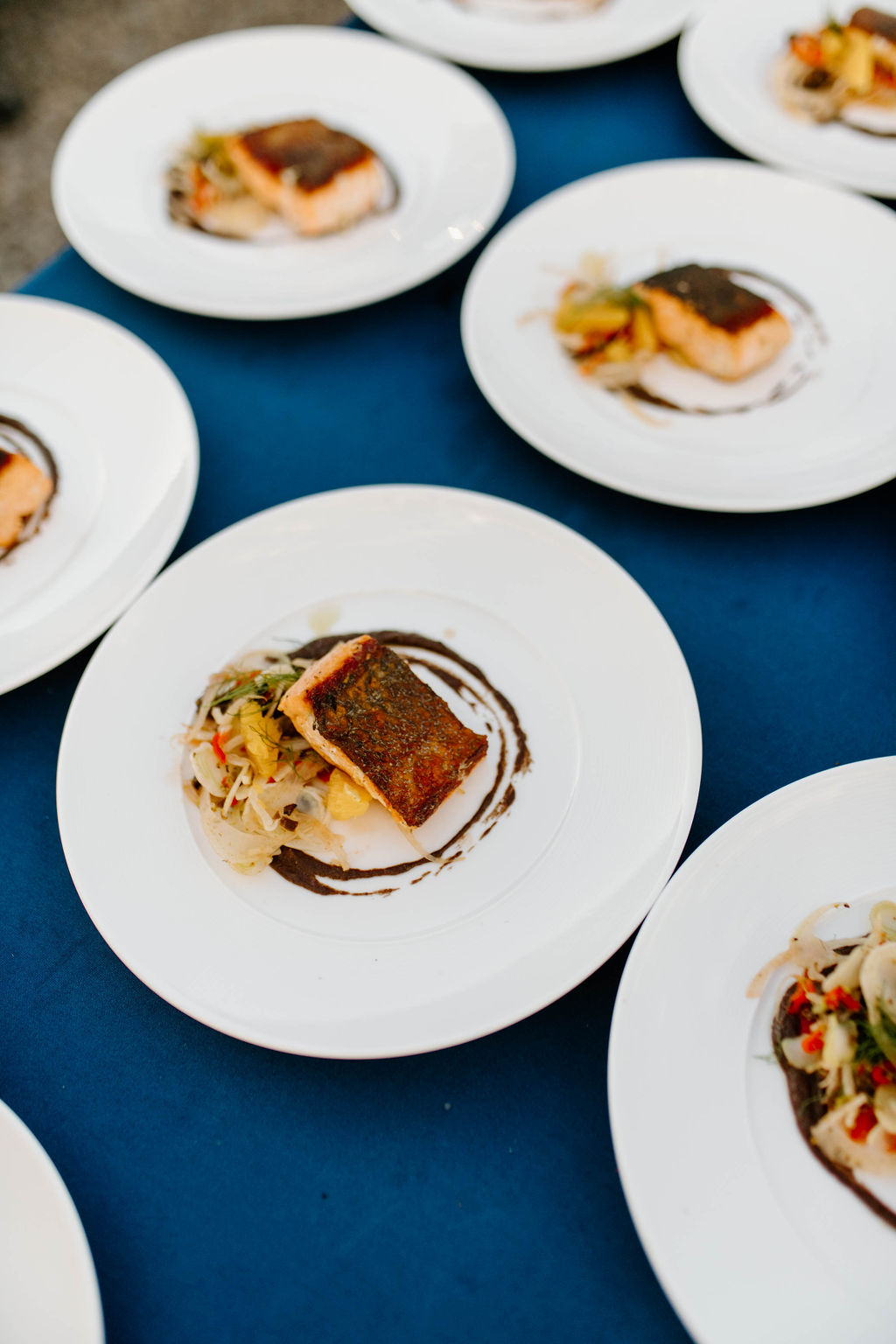 Plates of freshly grilled salmon, artfully decorated and ready to be served at a wine dinner.